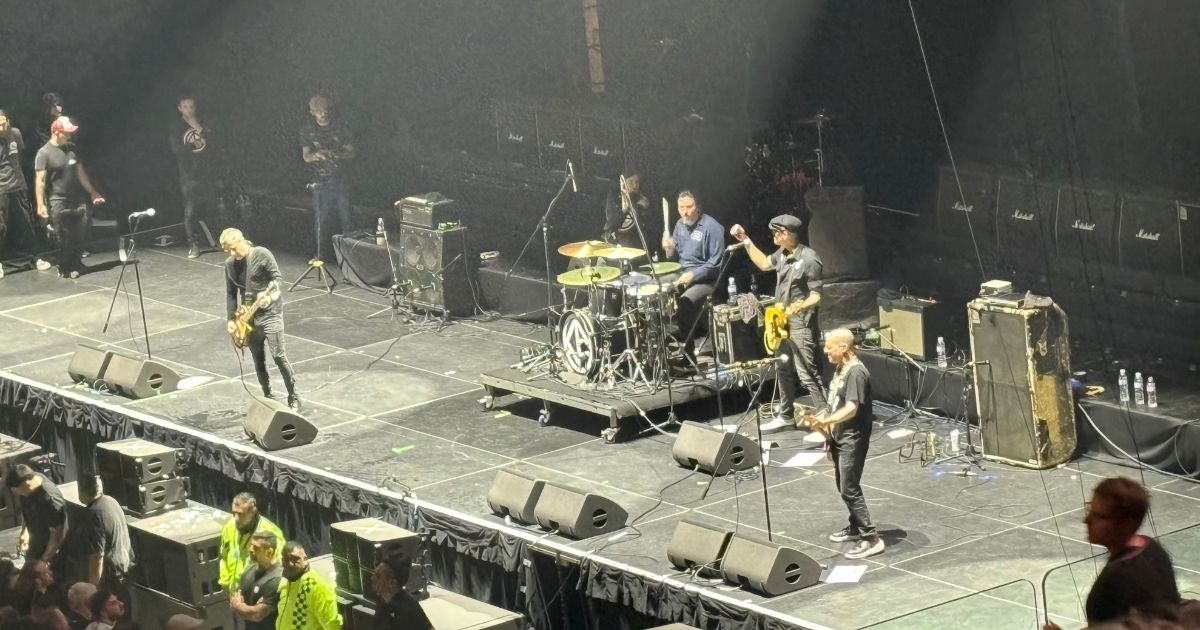 Cadena Perpetua onstage at Movistar Arena in Buenos Aires: the four members under white spotlights, the drum kit in the centre and a wall of Marshall cabinets behind them